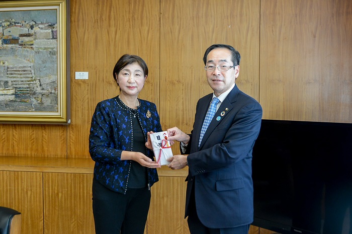 髙橋市長へ目録を手渡した松本惠子代表取締役