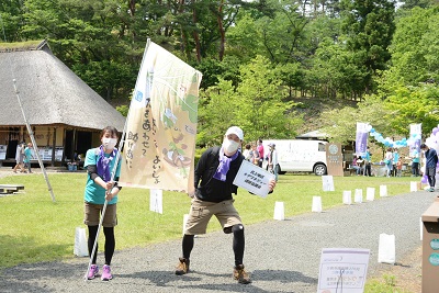 各団体の参加者はメッセージなどが書かれた旗を掲げながら同村内を思い思いに歩きました