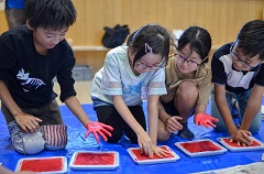 ピンク色やオレンジ色の水性塗料を使い、思いを込めて手形を押しました