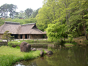 みちのく民俗村の湖のほとりに立つ昔ながらの家屋