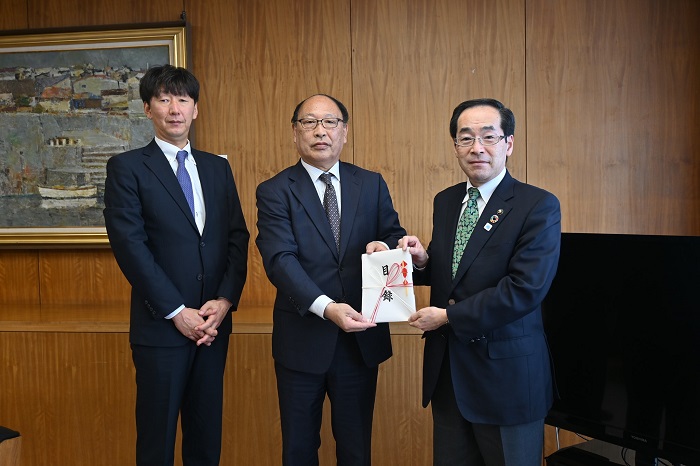 齋藤泰男専務取締役と佐々木一宏事業部長が市の本庁舎を訪れ、市長に目録を手渡しました