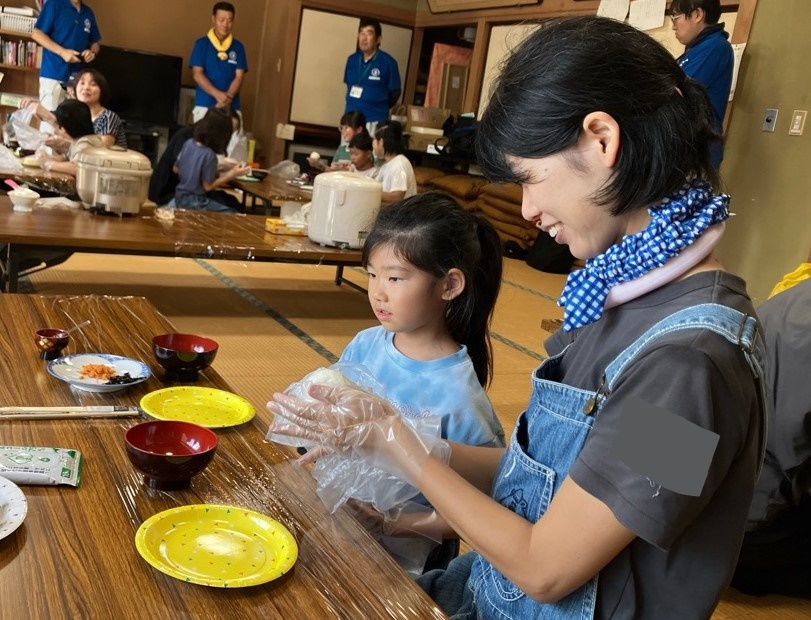 おにぎりの形を整える親子の写真